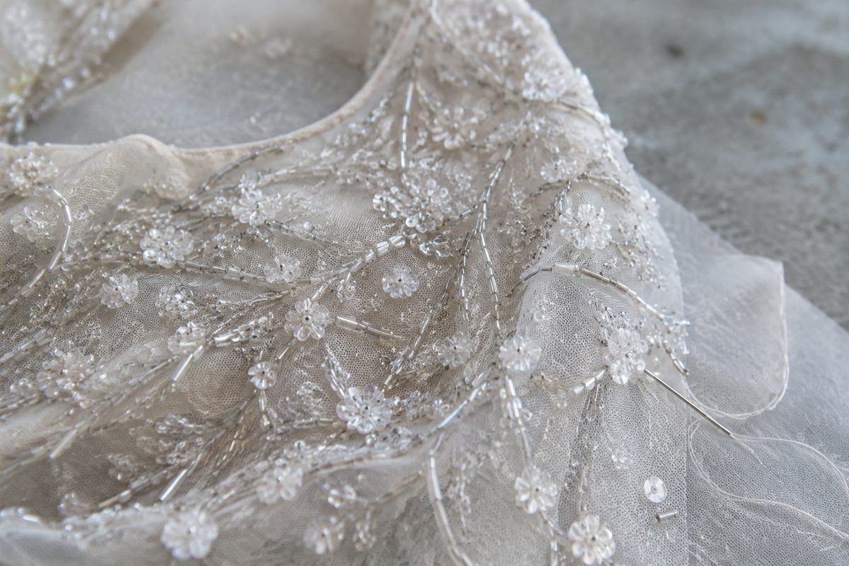 Close-up of glass bugle beads hand-sewn onto an illusion tulle bodice